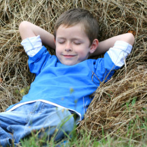 6-7 years old boy lying on haystack - summer time